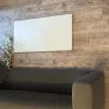 Prémium, fehér üveg infrapanel egy modern, minimalista nappali falán, egy elegáns kanapé fölött 600W