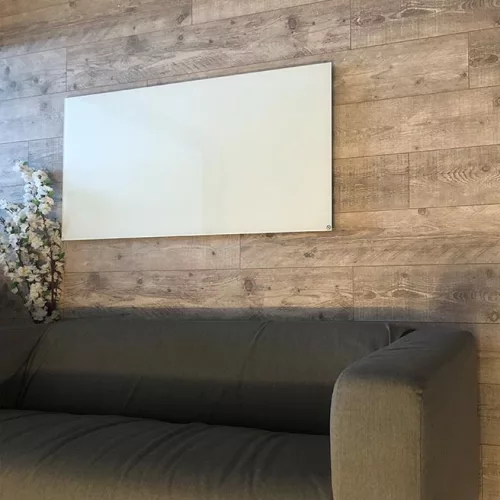 Prémium, fehér üveg infrapanel egy modern, minimalista nappali falán, egy elegáns kanapé fölött 600W