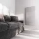 Prémium, fehér üveg infrapanel egy modern, minimalista nappali falán, egy elegáns kanapé fölött 800W